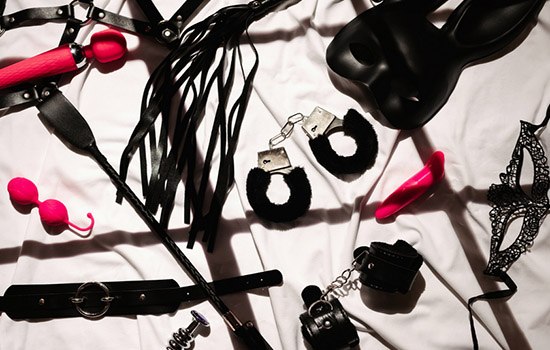 Role-playing toys like a bunny mask, cuffs, leather straps, and pink sex toys